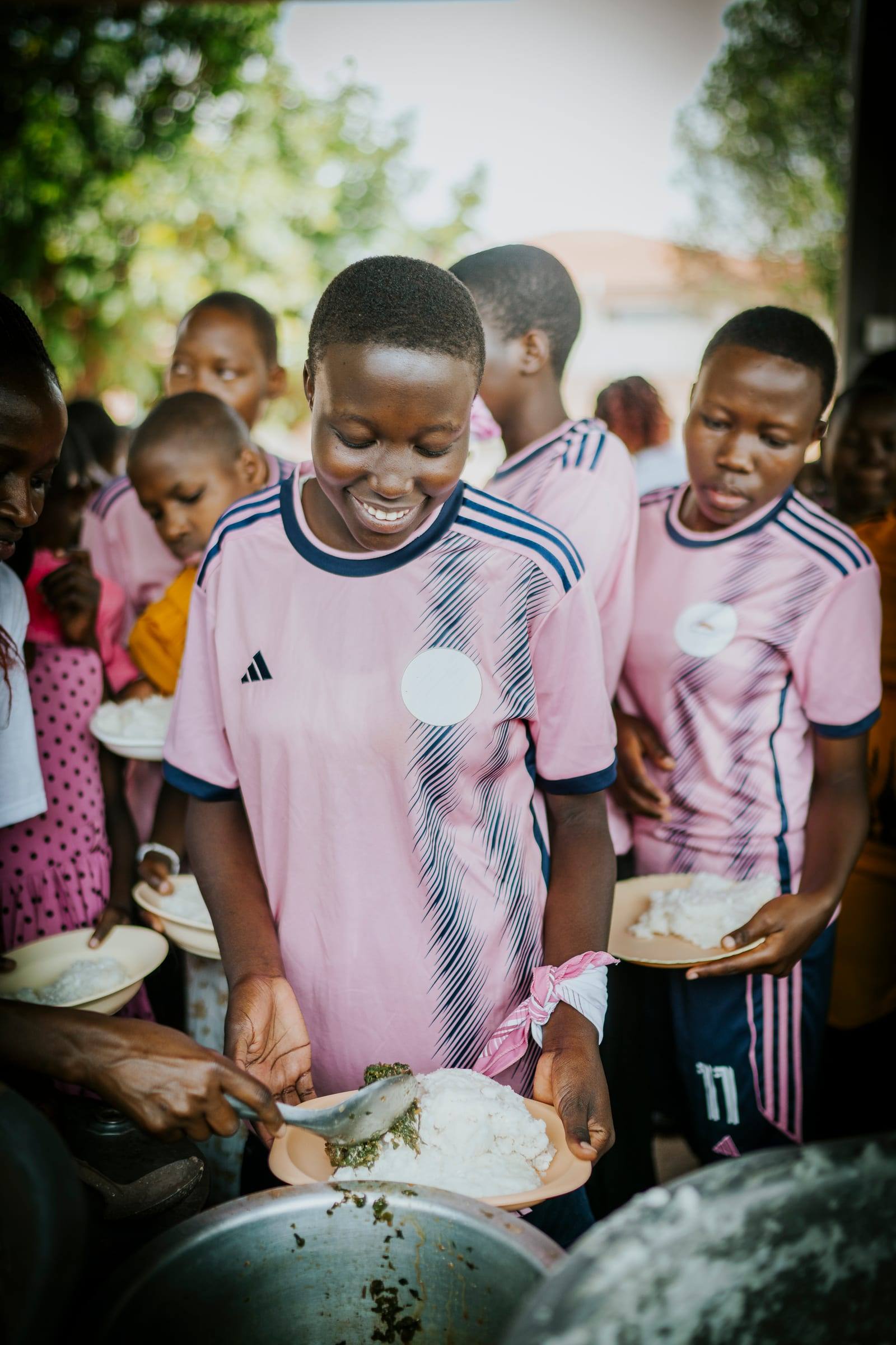 Smiling students line up for a hot meal