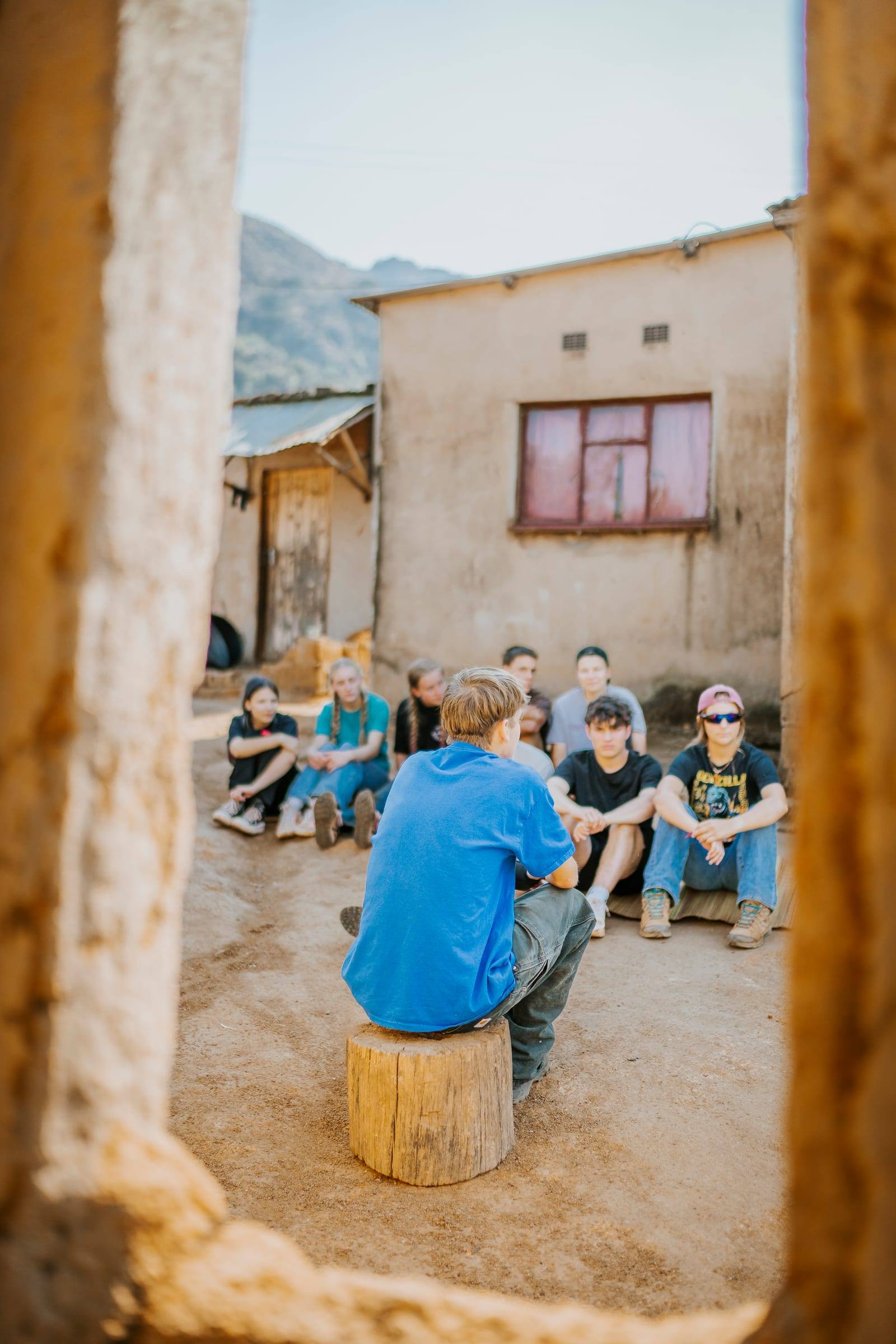 A group sits together in a circle in a small courtyard