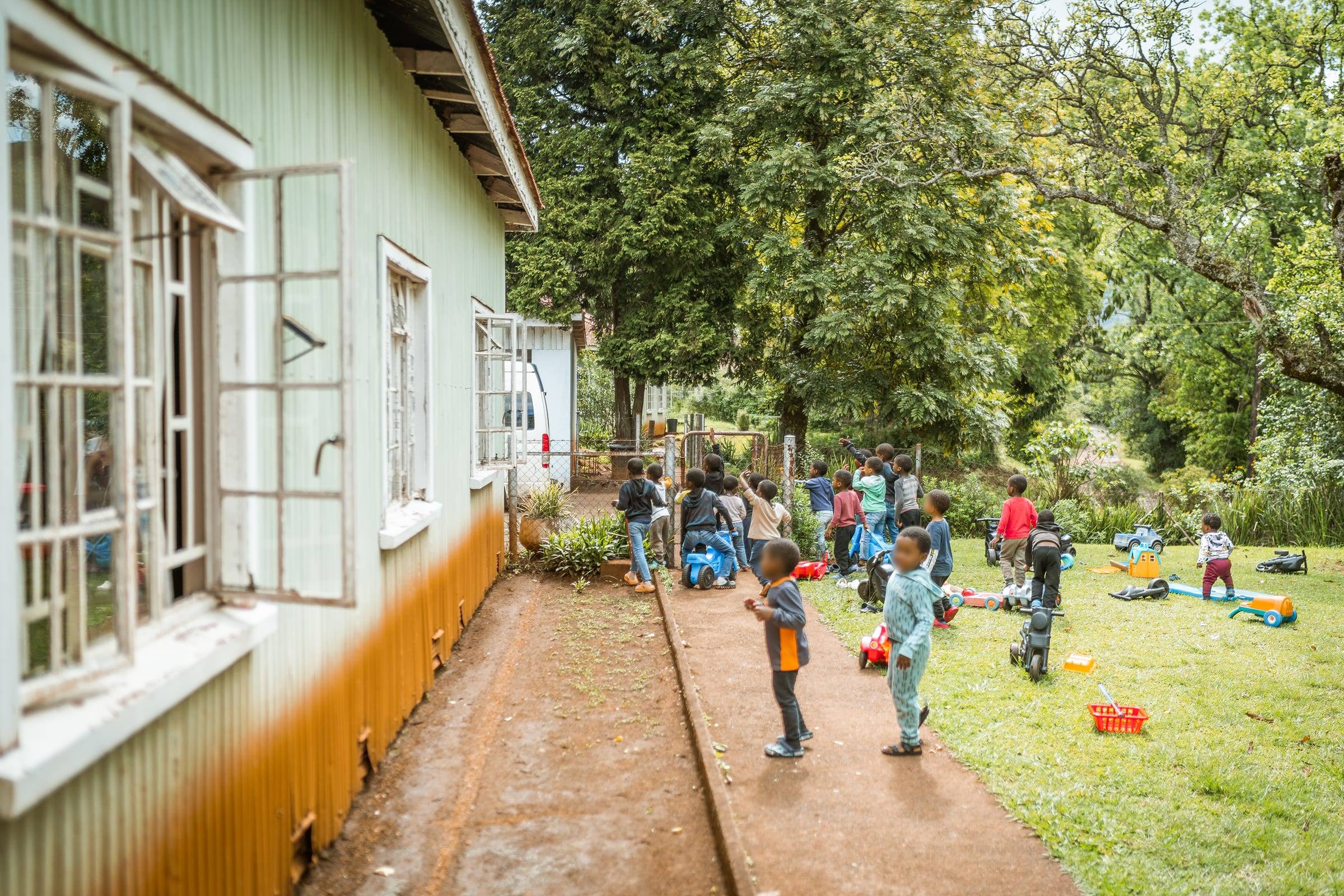 Children play in the yard beside a school building